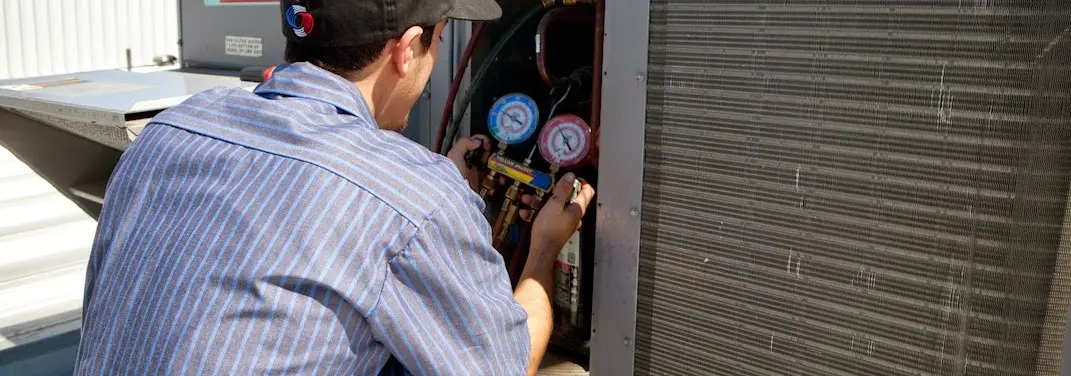 HVAC technician servicing a condenser unit in Schertz